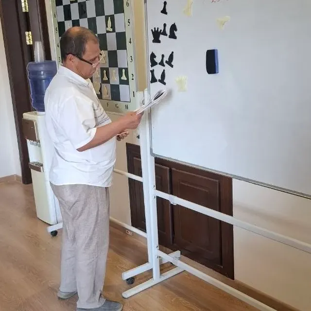 Chess teacher next to the demonstration board